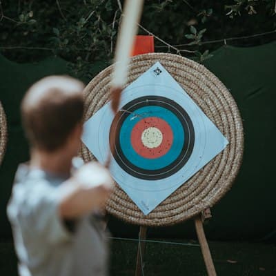 Een boogschutter, van achteren gezien, mikt op een doel